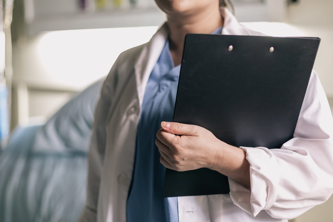 Crop of medical doctor holding a clipboard.